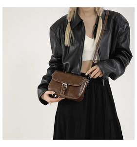 Sac bandoulière rétro marron en cuir PU avec boucle argentée porté par un mannequin