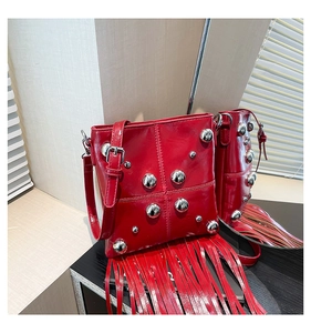 Dettaglio della borsa punk rossa con rivetti d'argento e lunghe frange in pelle