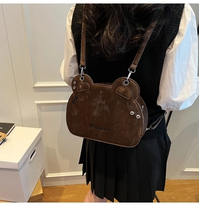 Close-up of brown bear-shaped crossbody bag with Princess embroidery and stud details