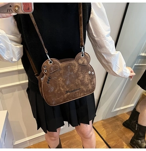 Detail of cute bear-shaped crossbody bag in brown suede with Princess embroidery