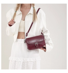 Vue détaillée du sac bandoulière bordeaux vintage avec coutures contrastées et boucle