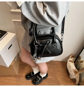 Dettaglio borsa bowling nera con fiocco decorativo e ciondolo a forma di coniglio