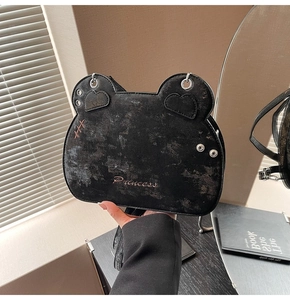 Detail of black bear-shaped shoulder bag with Princess embroidery and heart ear patches