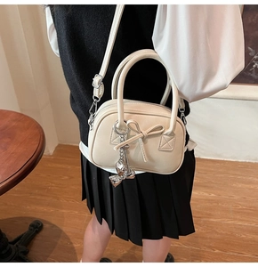 Dettaglio mini borsa bowling bianco off-white con fiocco e tracolla regolabile
