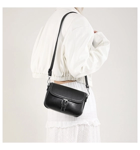 Détail du sac bandoulière noir avec surpiqûres blanches contrastées et fermoir argenté