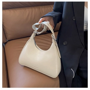 Detail of cream hobo bag showing the embossed FASHION & BAG logo on leather