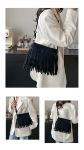 Détail d'un sac bandoulière bohème en daim noir avec franges et boucle dorée