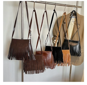 Groupe de sacs à bandoulière bohèmes avec de longues franges sur un support en métal