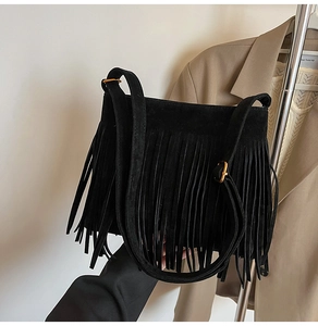 Detailansicht der schwarzen Wildledertasche mit langen Fransen und goldener Schnalle
