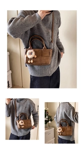 Gros plan sur le sac seau tissé marron avec bandoulière et breloque lion en peluche