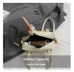 Detail view of the beige crossbody bag showing its internal capacity and zipper closure