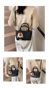 Détails du sac seau noir tressé avec un joli pendentif ours en peluche marron attaché