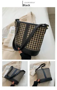Detail of houndstooth bucket bag featuring black leather trim and fine white stitching