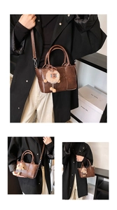Détail d'un sac seau tressé marron avec texture cuir et charmant pendentif en peluche