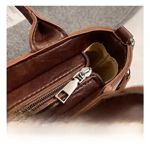 Détail du sac seau en cuir marron avec zip argenté et doublure intérieure kaki