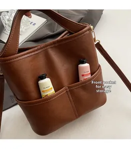 Detail view of brown bucket bag showing front pockets for convenient storage