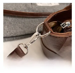 Gros plan sur la boucle en métal argenté et le cuir marron grainé avec coutures