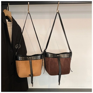 Detail of vintage suede bucket bags with metal rivets and long leather shoulder straps