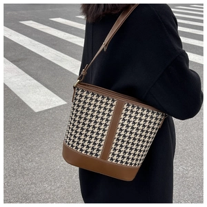 Close-up of houndstooth patchwork bucket bag with adjustable leather shoulder strap