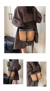 Detail of vintage suede crossbody bag with metal rivets and contrast leather trim