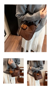 Detailed view of the dark brown leather bucket bag with cute bear charm and tassel
