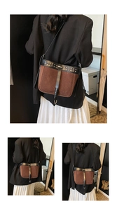 Detail of retro bucket bag featuring brown suede contrast with metal stud embellishments