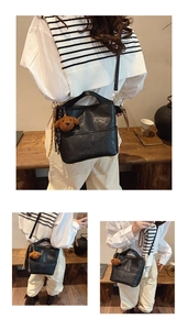 Chic black bucket bag with bear charm and woven strap shown in a lifestyle setting