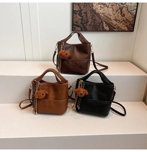 Three bucket bags in dark brown and black with cute puppy charms on white tiers