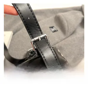 Detail of adjustable black leather strap with silver metal buckle on a retro crossbody bag