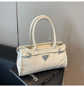 Detail of minimalist cream PU leather tote bag with iconic triangle metal logo plaque