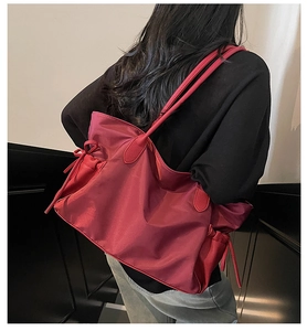 Détail du grand sac cabas rouge en nylon avec nœud coulissant et poignée en cuir
