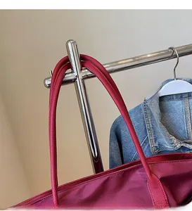 Détail du sac cabas bordeaux avec bandoulière longue en cuir lisse et tissu de haute qualité