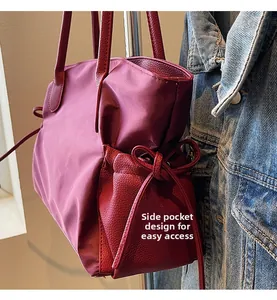 Vue détaillée d'un sac cabas bordeaux avec poche latérale à cordon et nœud élégant