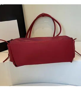 Détail du sac cabas bordeaux avec texture cuir grainé sur un support blanc