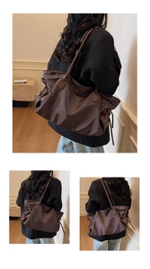 Détails de ce grand sac fourre-tout marron foncé avec plis latéraux à cordon et texture de cuir