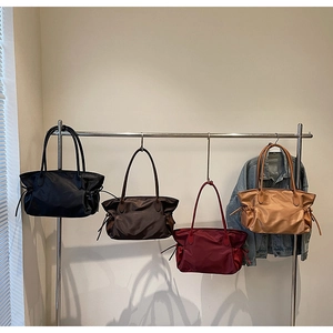 Détail de quatre sacs cabas en nylon coloré avec cordons latéraux et longues anses