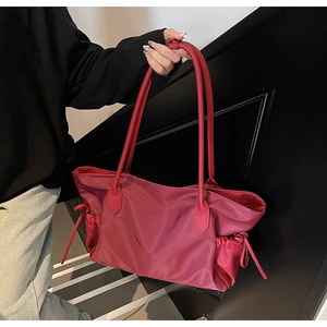 Détail du sac de voyage bordeaux en nylon avec poche latérale à cordon et anses solides