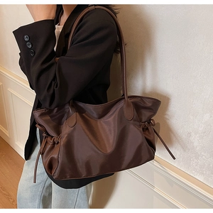 Détail du grand sac de voyage marron foncé avec cordon de serrage en nylon et cuir