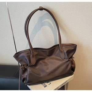 Détail du sac fourre-tout en nylon marron foncé avec coutures en cuir et cordon latéral