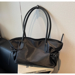 Détail du sac cabas en nylon noir avec cordon de serrage et poignées en cuir grainé
