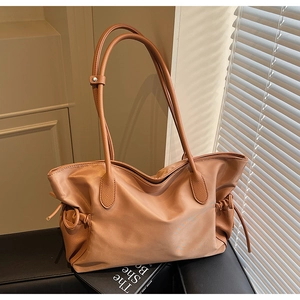 Vue détaillée du sac cabas caramel montrant les cordons latéraux et textures en cuir