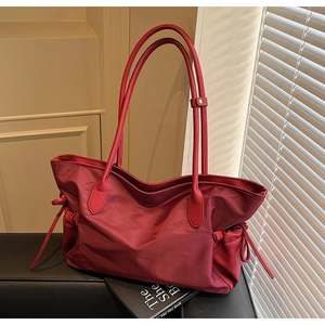 Détail du grand sac de voyage rouge avec poches latérales à cordon et tissu en nylon