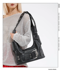 Détail du sac punk noir avec de grandes boucles argentées et des œillets métalliques