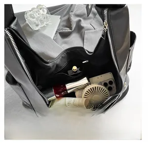Top view of spacious interior of black leather shoulder bag with zipper and metal eyelets