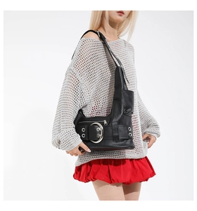 Detail of black punk shoulder bag featuring oversized silver buckle and metal eyelets