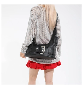 Détail du sac sous le bras en cuir noir avec boucle fer à cheval argentée et oeillets