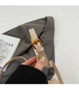 Detail of adjustable beige leather shoulder strap with high-quality golden metal buckle