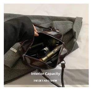 Detail view of the spacious internal capacity of this brown glossy shoulder bag