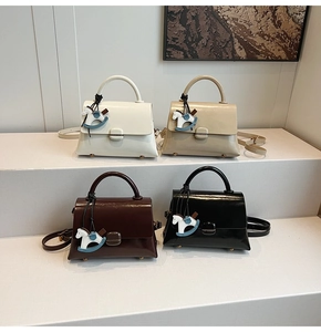 Group shot of four large capacity tote bags in white, beige, brown, and black with horse charms