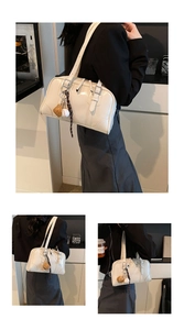 Detail of cream leather bowling bag with creative baseball glove pendant and adjustable strap